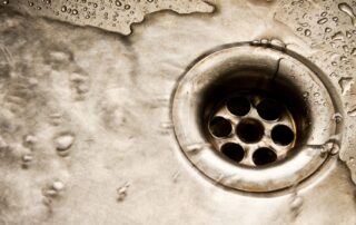 Close-up of water flowing into metal drain