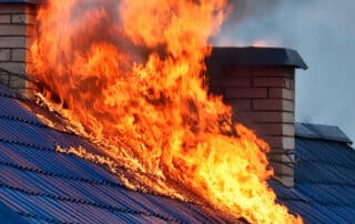 A house roof engulfed in flames, emphasizing the need for fire damage restoration services to repair and restore the structure after fire damage.