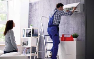 Technician repairing air conditioner at home. Home Maintenance Checklist