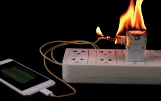 Power strip with phone charger on fire.