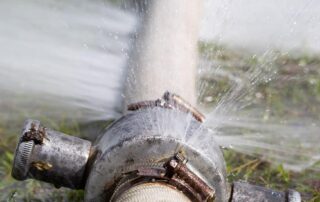Leaking pipe spraying water outdoors
