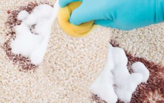 Cleaning carpet stains with sponge and detergent foam.