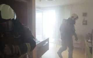 Firefighters in a smoke-filled room during operation, emphasizing the need for smoke damage cleanup to restore and remove smoke residue from the space.