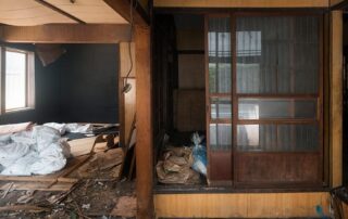 Abandoned, dilapidated room with broken windows and debris.
