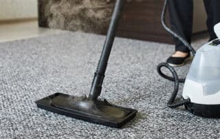Professional carpet cleaner using specialized equipment to remove water and restore a carpet after flood or water damage.